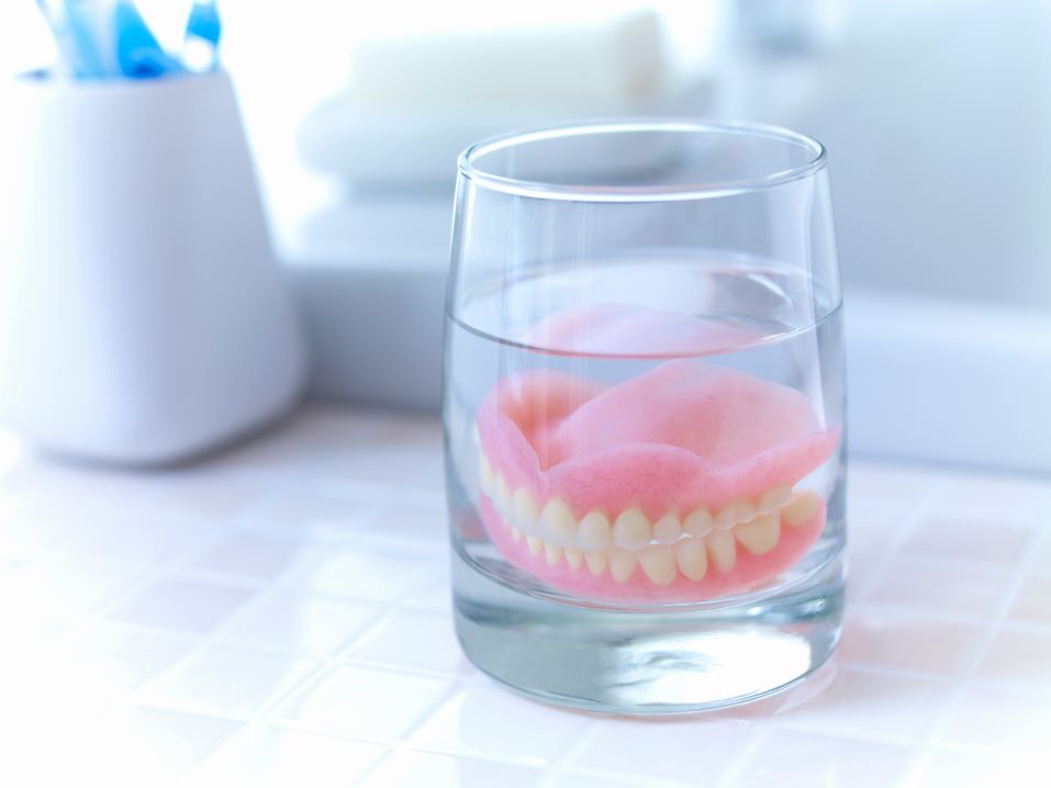 Dentures soaking in a glass of liquid