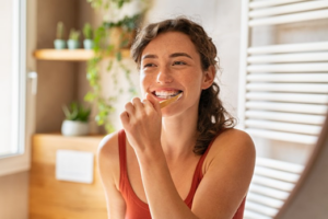 Woman smiling and brushing her teeth